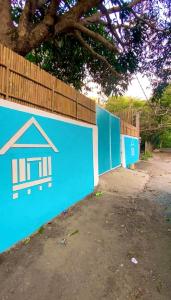 a blue retaining wall with a house painted on it at Shigemary Kubohouse in Capepisa +7 photos