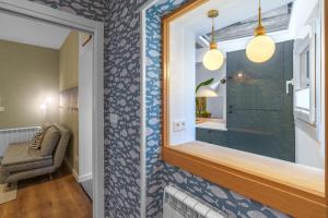 a bathroom with a mirror and a chair at SEBASTIAN Apartamentos in Getaria