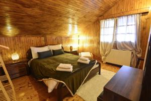 a bedroom with a bed in a wooden room at Casa di Fiamengo in Ano Trikala