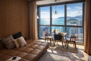 a living room with a couch in front of a large window at premium ocean view in HAEHUNDAE BONA TOGETHER in Busan
