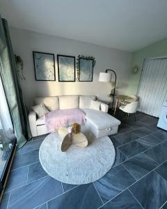 a living room with a couch and a table at Le Cocon de Laroque in Laroque +1 photo