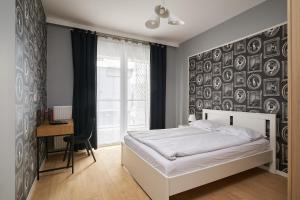 a bedroom with a white bed and a wall with pictures at Apartamenty City Tower od WroclawApartament-pl in Wrocław +246 photos