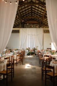 a banquet hall with tables and chairs and white drapes at Rusiborek Slow in Murzynowo Kościelne