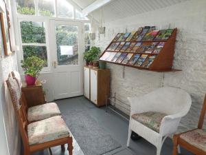 a room with chairs and a shelf with books at The Denes Guest House in Lynton