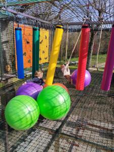 a child playing in a playground with colorful balls at Camping Domaine de Senaud in Albon +20 photos