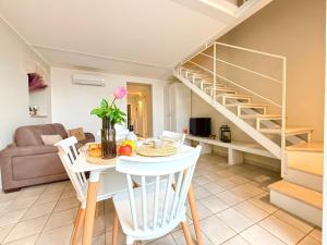 a living room with a table and a spiral staircase at Residenza Garibaldi in Monopoli