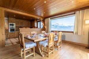 a kitchen with a table and chairs and a large window at Chalet Sapi in Combloux