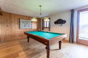 a pool table in a room with wooden walls at Chalet Sapi in Combloux