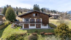 a large house on a hill with a yard at Chalet Sapi in Combloux +11 photos