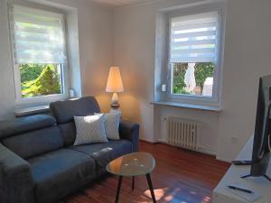 a living room with a couch and two windows at Ferienhaus by Rossano Boutique Hotel & Ristorante in Ansbach
