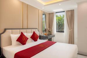 a bedroom with a large bed with red pillows at Bailey Hotel Hue in Hue +89 photos