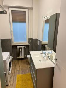 a bathroom with a sink and a toilet and a window at Maison Regina in Vigevano