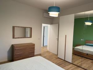 a bedroom with a bed and a dresser and a mirror at Maison Regina in Vigevano