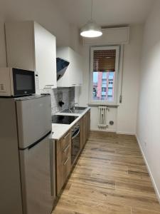 an empty kitchen with a refrigerator and a sink at Maison Regina in Vigevano