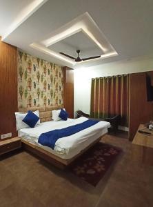 a bedroom with a large bed with blue pillows at Hotel Padma Residency in Datia