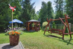 a garden with a bench and a gazebo at Kalipso nad Jeziorem Białym in Okuninka