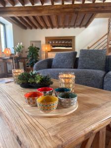 a wooden table with bowls on top of it at Le Chêne Guesthouse in Aunou-sur-Orne