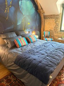 a bed with a blue comforter and two pillows at Le Chêne Guesthouse in Aunou-sur-Orne +33 photos