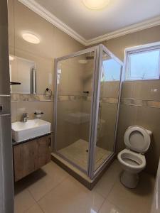 a bathroom with a shower and a toilet and a sink at Bayside Hotel Empangeni in Empangeni
