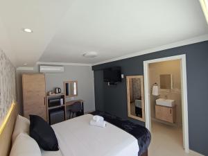a bedroom with a white bed and a couch at Bayside Hotel Empangeni in Empangeni
