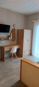 a bedroom with a desk and a bed with a chair at Seaside Studios in Paralia Dionysiou