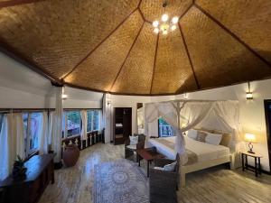a bedroom with a bed and a room with a table at The Palms - Seraya Shores Retreat Bali in Seraya