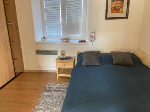 a bedroom with a blue bed and a window at Luxusný apartmán u Loly in Polomka