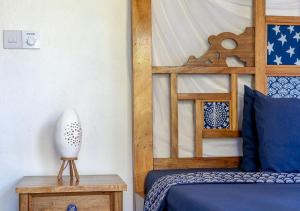 a bedroom with a bed with a wooden head board at Dhow House - Rooftop Lounge with Sunrise Views in Bagamoyo