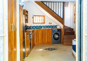 a kitchen with a washing machine and a staircase at Dhow House - Rooftop Lounge with Sunrise Views in Bagamoyo