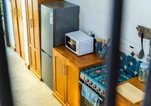 a kitchen with a microwave on top of a stove at Dhow House - Rooftop Lounge with Sunrise Views in Bagamoyo