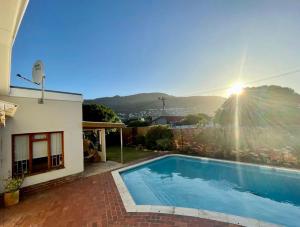 a swimming pool in front of a house at Serenity in Fish Hoek