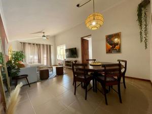 a dining room and living room with a table and chairs at Serenity in Fish Hoek