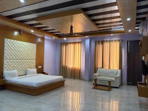 a bedroom with a bed and a couch and a chair at Hotel Shyam Regency in Sabāthu