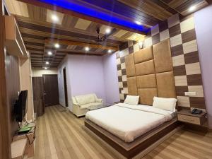 a bedroom with a bed and a couch and a tv at Hotel Shyam Regency in Sabāthu