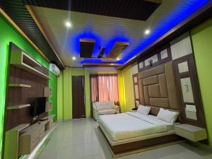 a room with a bed in a room with green walls at Hotel Shyam Regency in Sabāthu