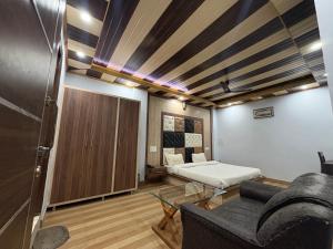 a living room with a bed and a couch at Hotel Shyam Regency in Sabāthu +4 photos