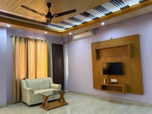 a living room with a chair and a tv at Hotel Shyam Regency in Sabāthu