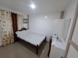 a small room with a bed and a refrigerator at Imari's Apartment in San Isidro