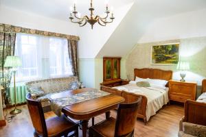 a bedroom with a bed and a table and a dining room at Cantervilla Castle in Otepää +67 photos