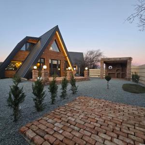 ein Haus mit einem Backsteinweg davor in der Unterkunft FreeDom Chalet in Verneşti