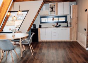 eine Küche und ein Esszimmer mit Tisch und Stühlen in der Unterkunft FreeDom Chalet in Verneşti