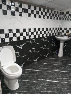 a bathroom with a toilet and a sink at Holiday Home Rathnaella in Hassalaka