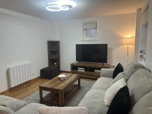 a living room with a couch and a flat screen tv at LaScala Apartment in Inverness