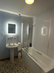 a bathroom with a sink and a shower and a tub at LaScala Apartment in Inverness