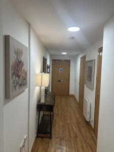 a hallway with a table and a door in a room at LaScala Apartment in Inverness