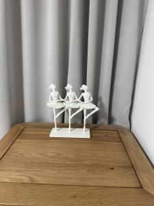 a white figurine of three women on a table at LaScala Apartment in Inverness +2 photos