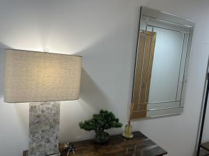 a lamp sitting on a table next to a mirror at LaScala Apartment in Inverness