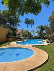 a large swimming pool in a yard with trees at Mediterranean Escape with Panoramic Sea Views in Benalmádena