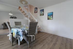 a dining room with a table and chairs and a staircase at Gite Kalon in Pouldreuzic