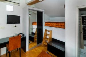 a room with a desk and a bedroom with a bunk bed at Hotel Boutique 36 in Sarajevo
